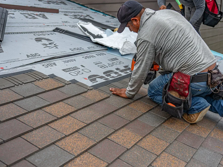 Roofer installing new shingles