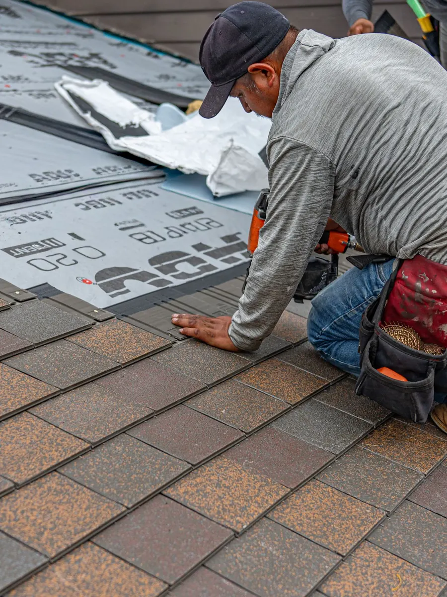 Roofer installing shingles